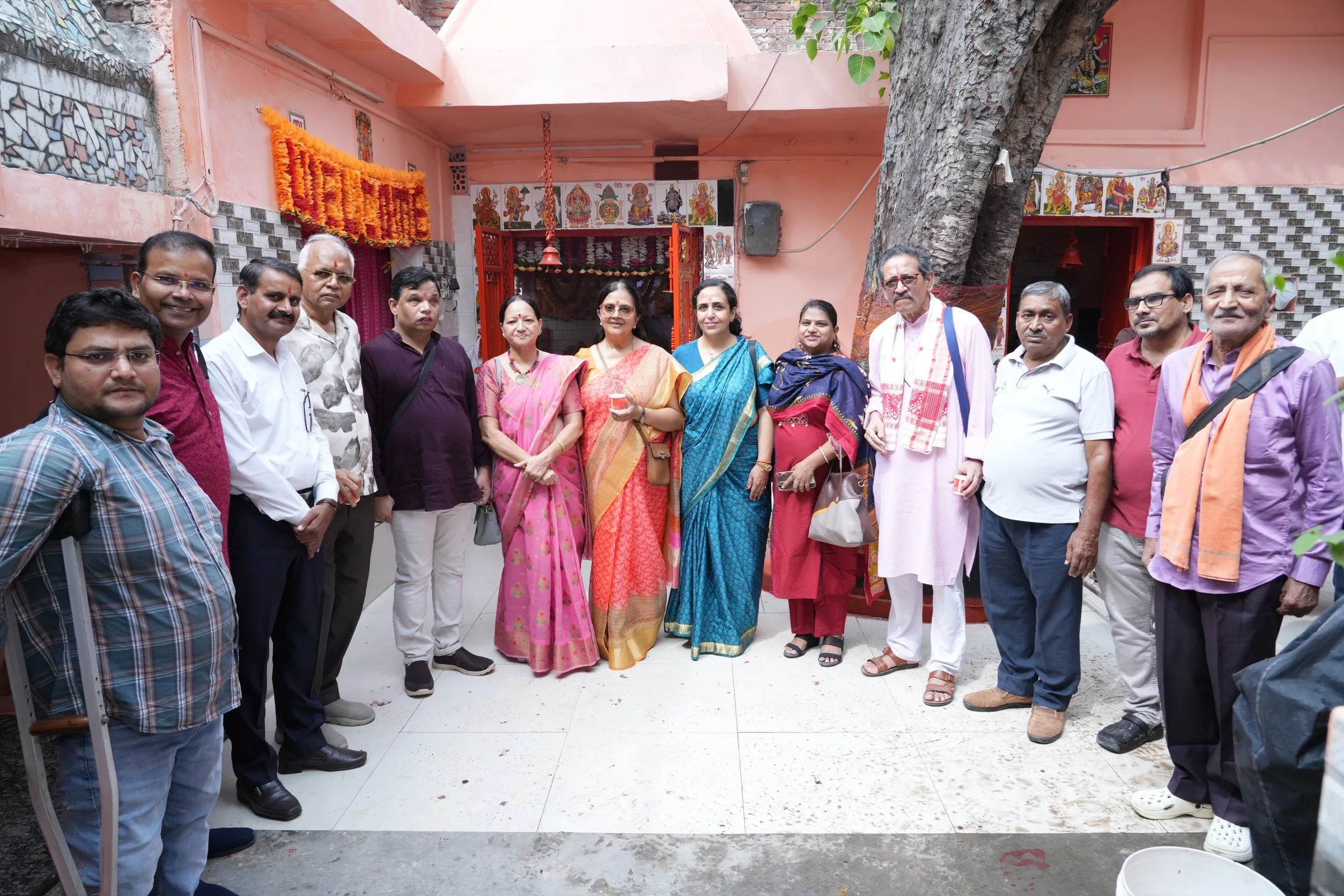 A large group of men and women standing together for a photo in a courtyard.